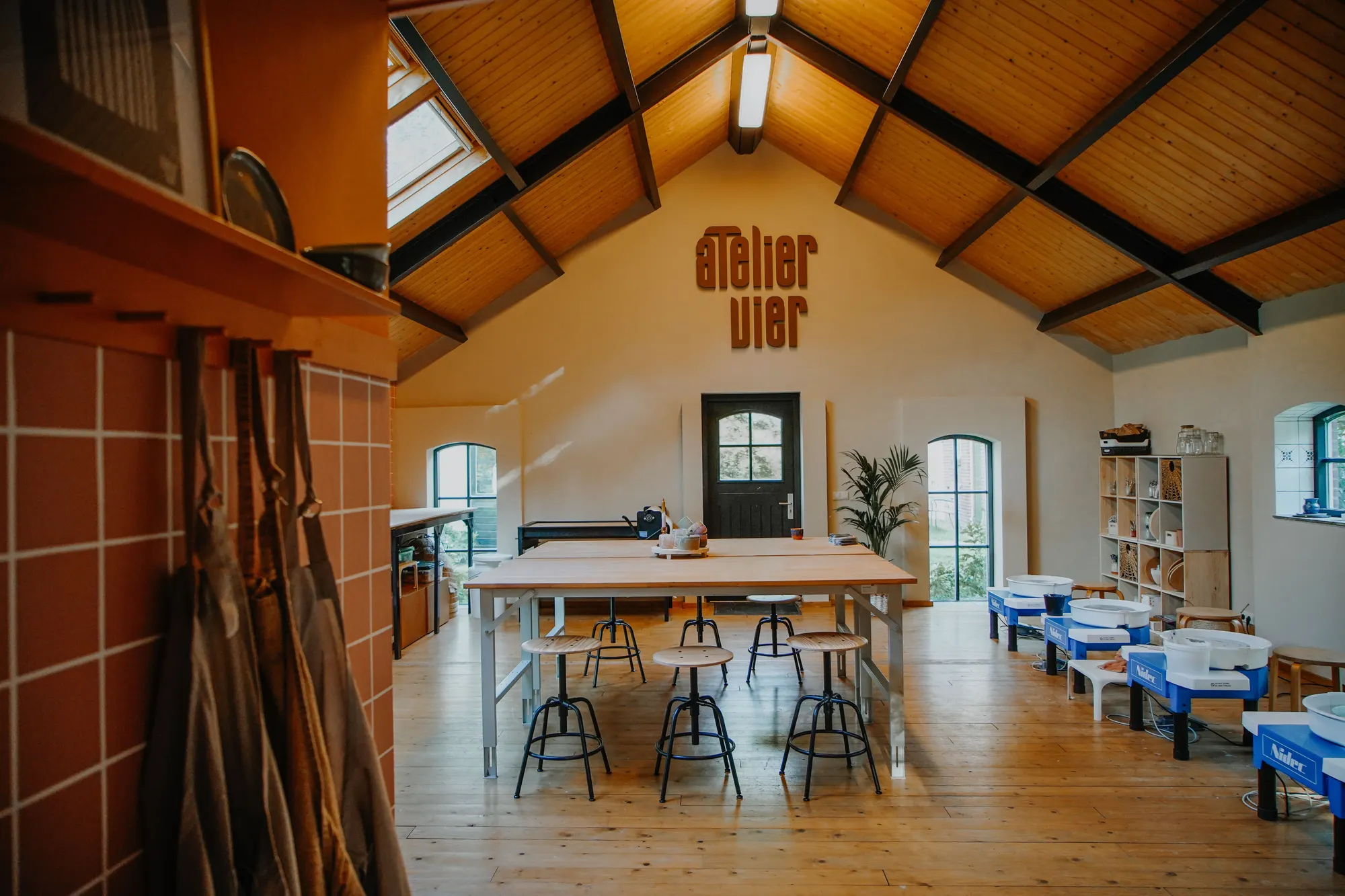Het atelier met draaischijven en lange tafel